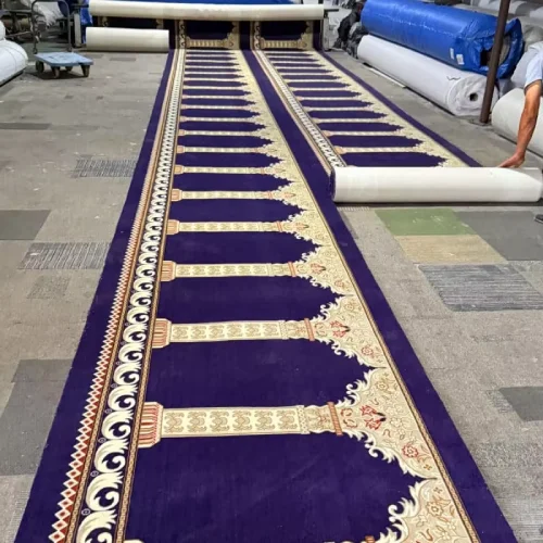 high pile mosque carpets featuring cream-colored arched prayer niche patterns and ornate floral borders being unrolled in a warehouse facility.